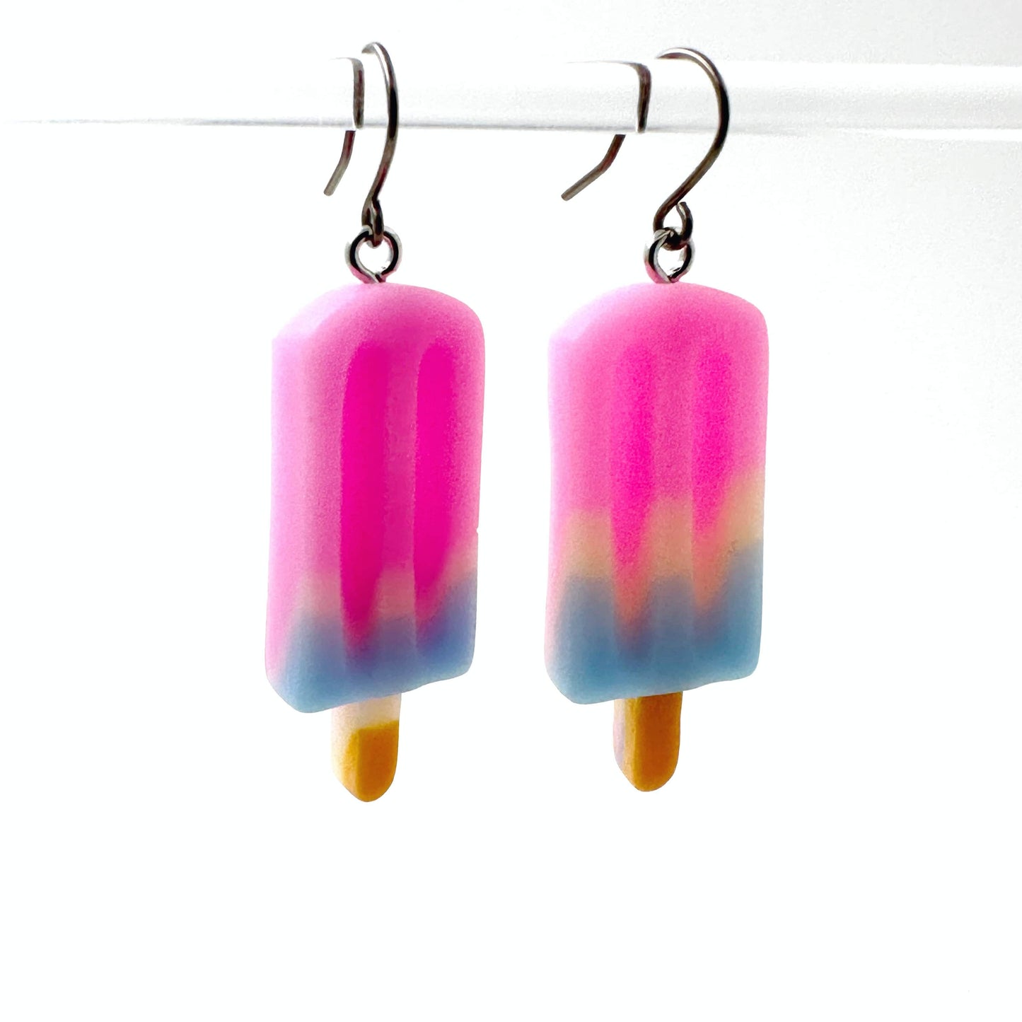 Popsicle earrings with a titanium hook on a white background.  pink blue white