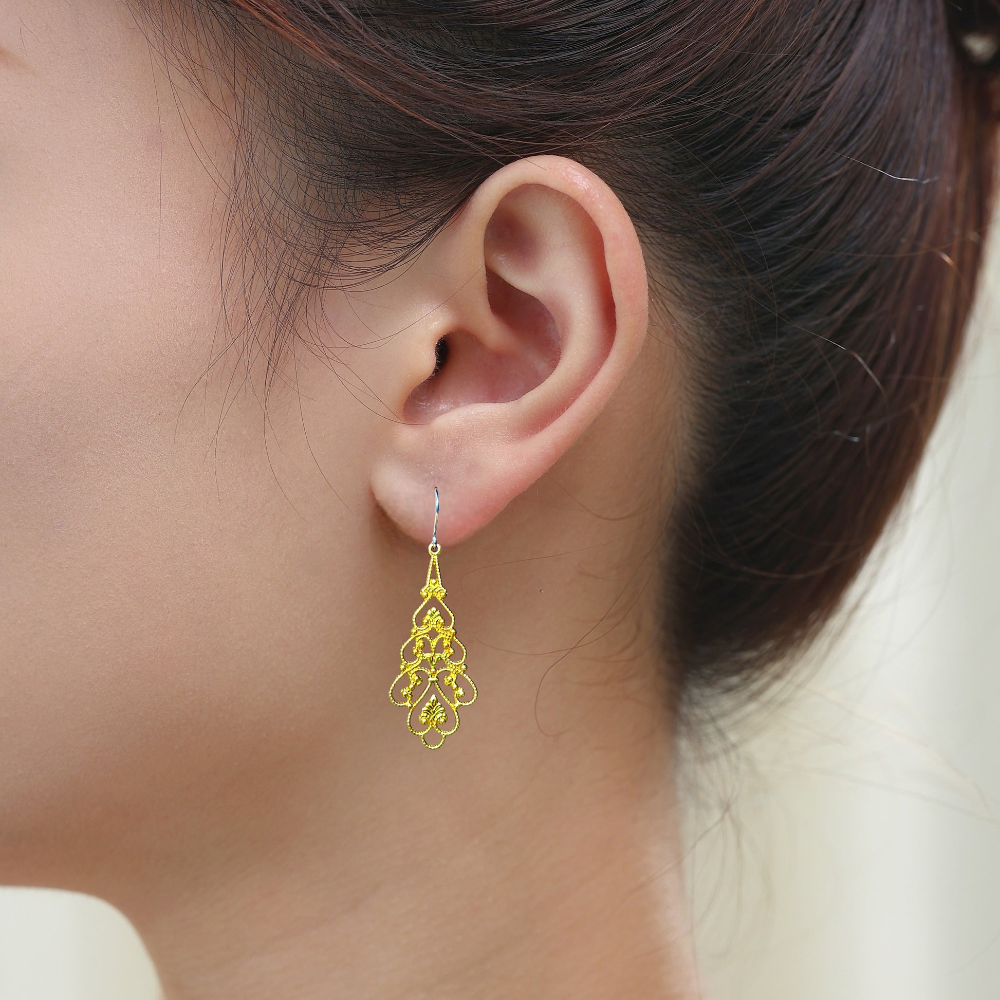 Princess Filigree earrings with a titanium hook on a white young woman