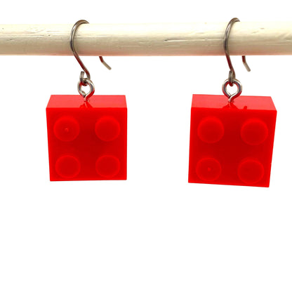 Red titanium LEGO block earrings on a white background