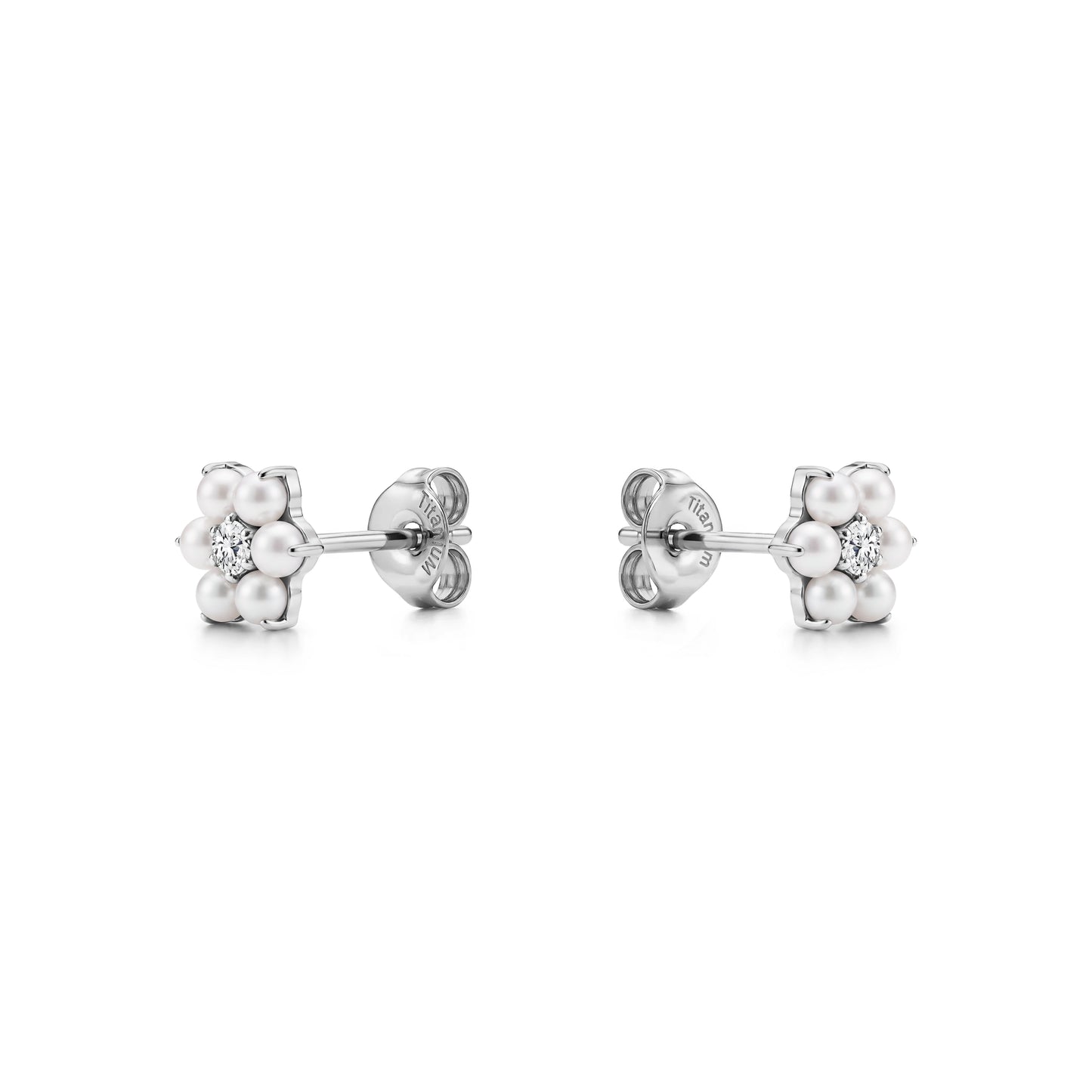 Pair of floral titanium stud earrings with pearls and a gem on a white background