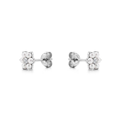 Pair of floral titanium stud earrings with pearls and a gem on a white background