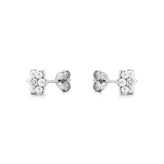Pair of floral titanium stud earrings with pearls and a gem on a white background