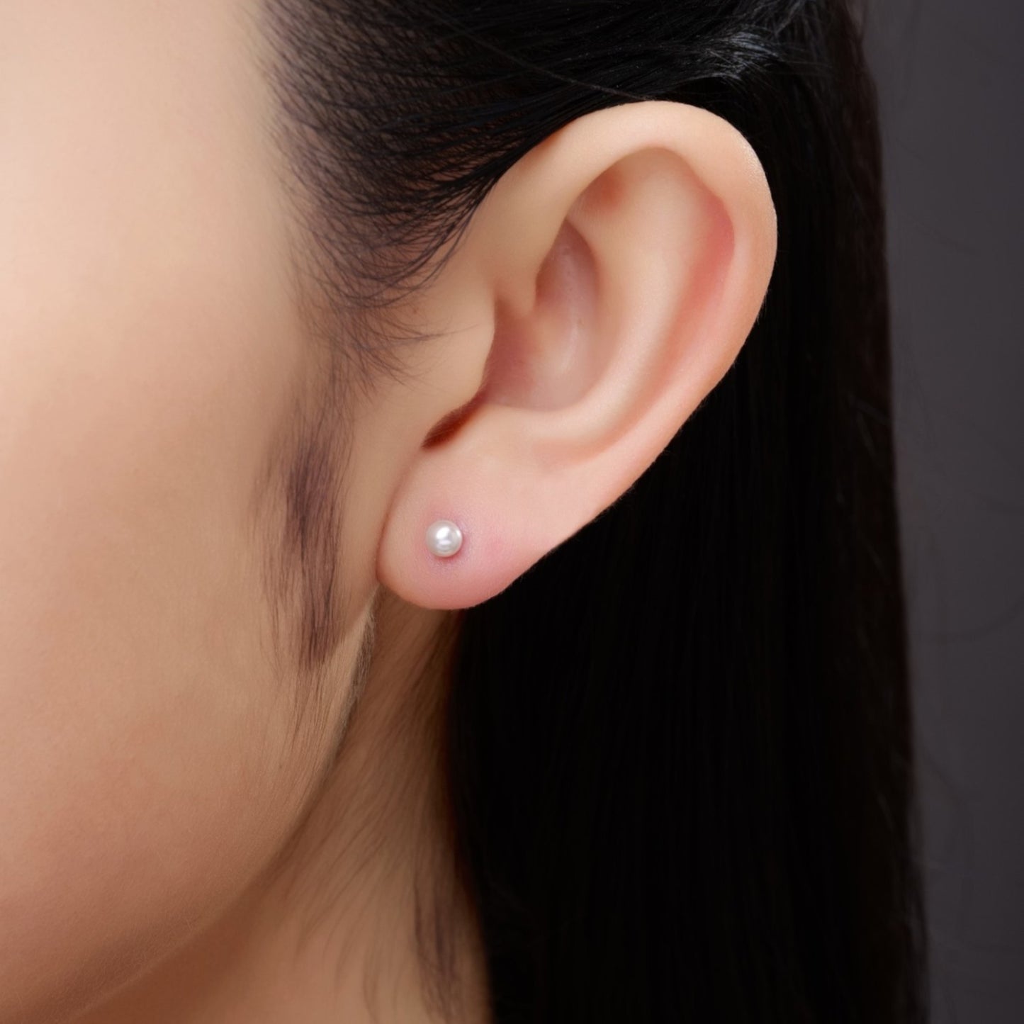 Pearl Studs 4mm solid titanium  Feature a small and minimal design on a white woman