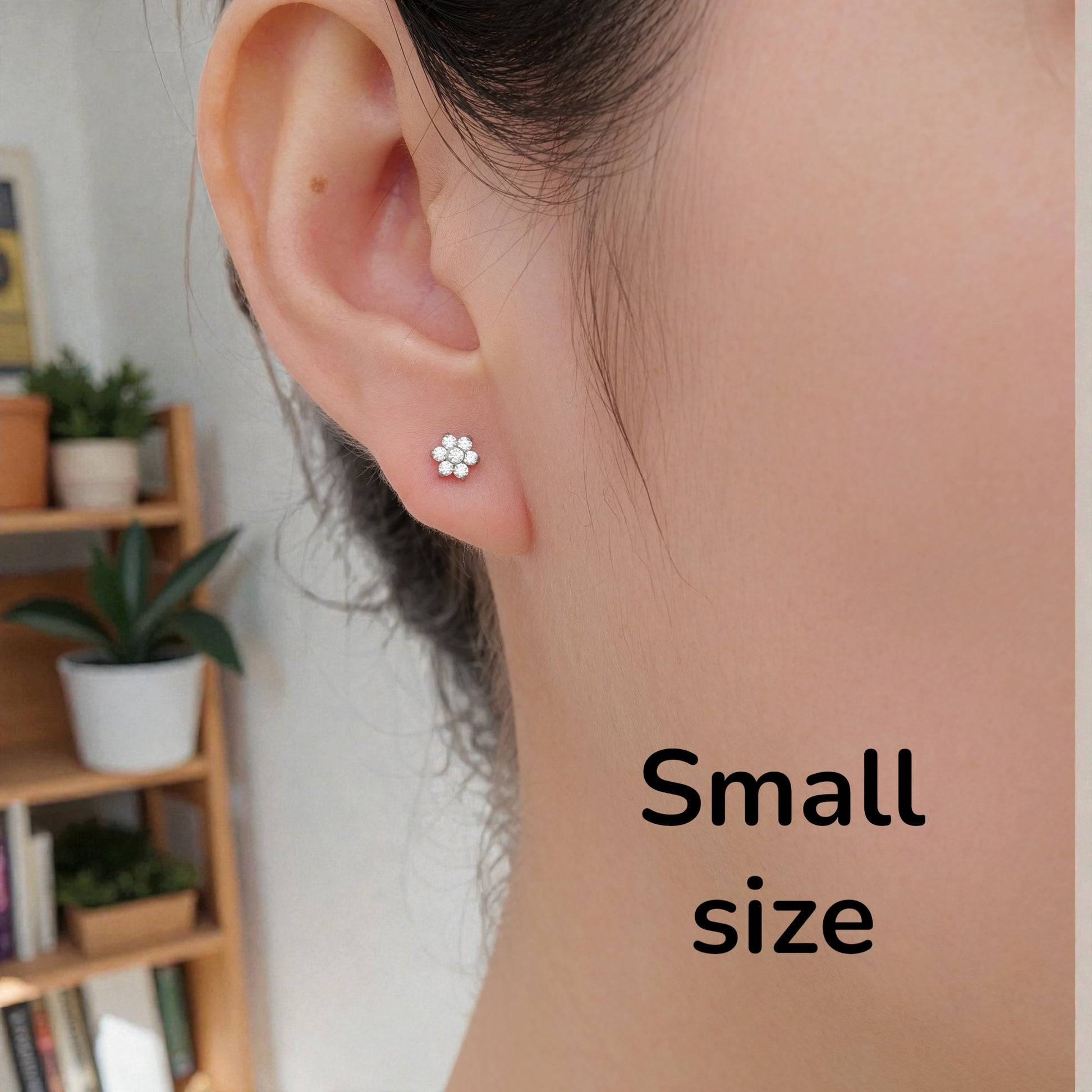 Flower ear studs with Gems. Titanium Studs 5mm adjustable fit studs shown on a woman.