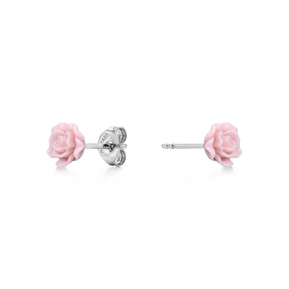 A pair of titanium stud earrings featuring light pink rose-shaped enamel tops, shown on a clean white background with one earring facing forward and the other showing the backing.