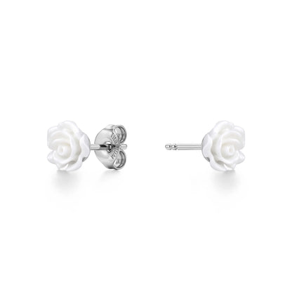 A pair of titanium stud earrings featuring white rose-shaped enamel tops, shown on a clean white background with one earring facing forward and the other showing the backing.