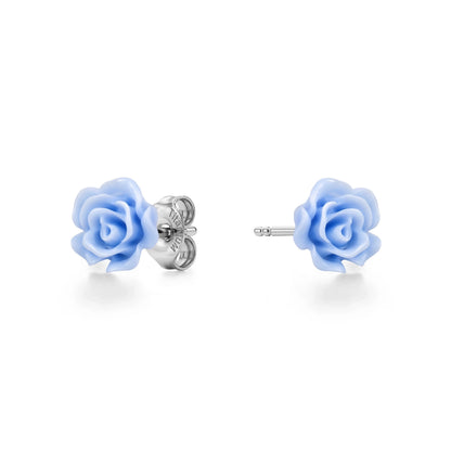 A pair of titanium stud earrings featuring pastel blue rose-shaped enamel tops, shown on a clean white background with one earring facing forward and the other showing the backing.
