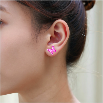 A close-up of a person's ear wearing a small butterfly-shaped titanium stud earring in shade of pink, and clear.