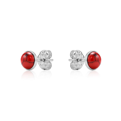 Pair of titanium earrings with red stones on a white background