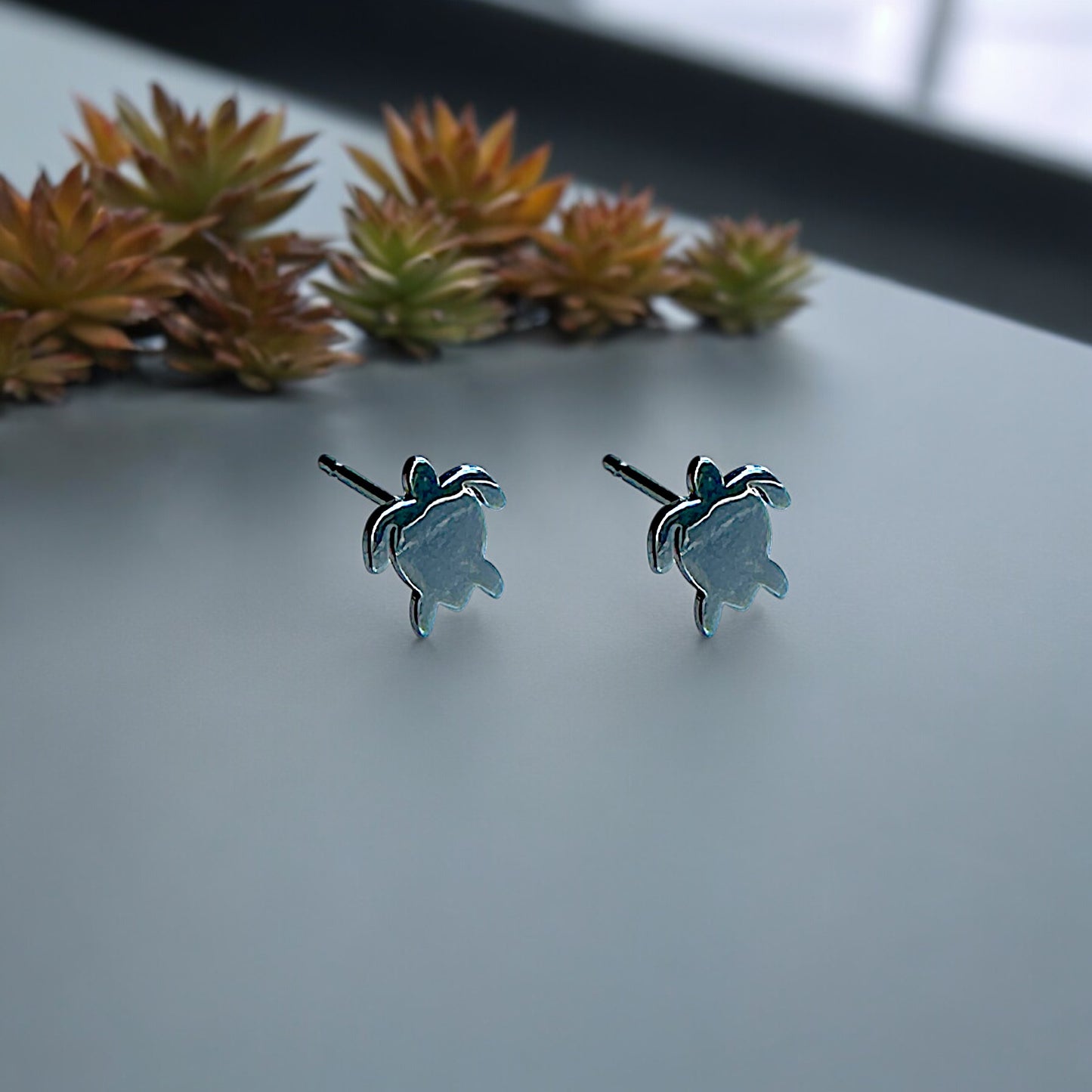 Turtle Studs -solid titanium studs and backs- Feature a small and minimal design on a white background