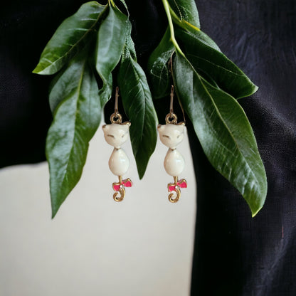 Siamese Charm earrings with a titanium hook on a white background . white