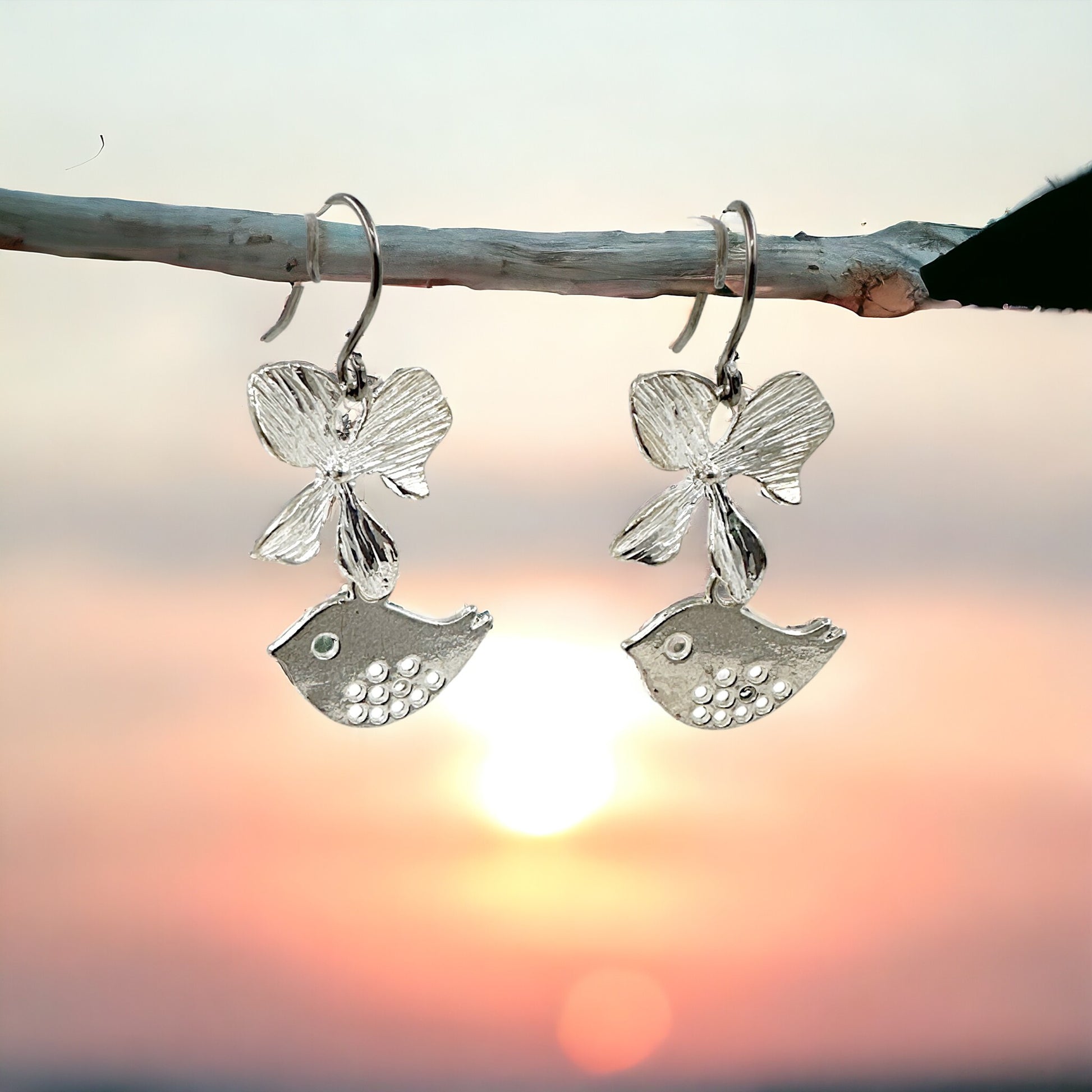 Songbird Charm earrings with a titanium hook on a sky background