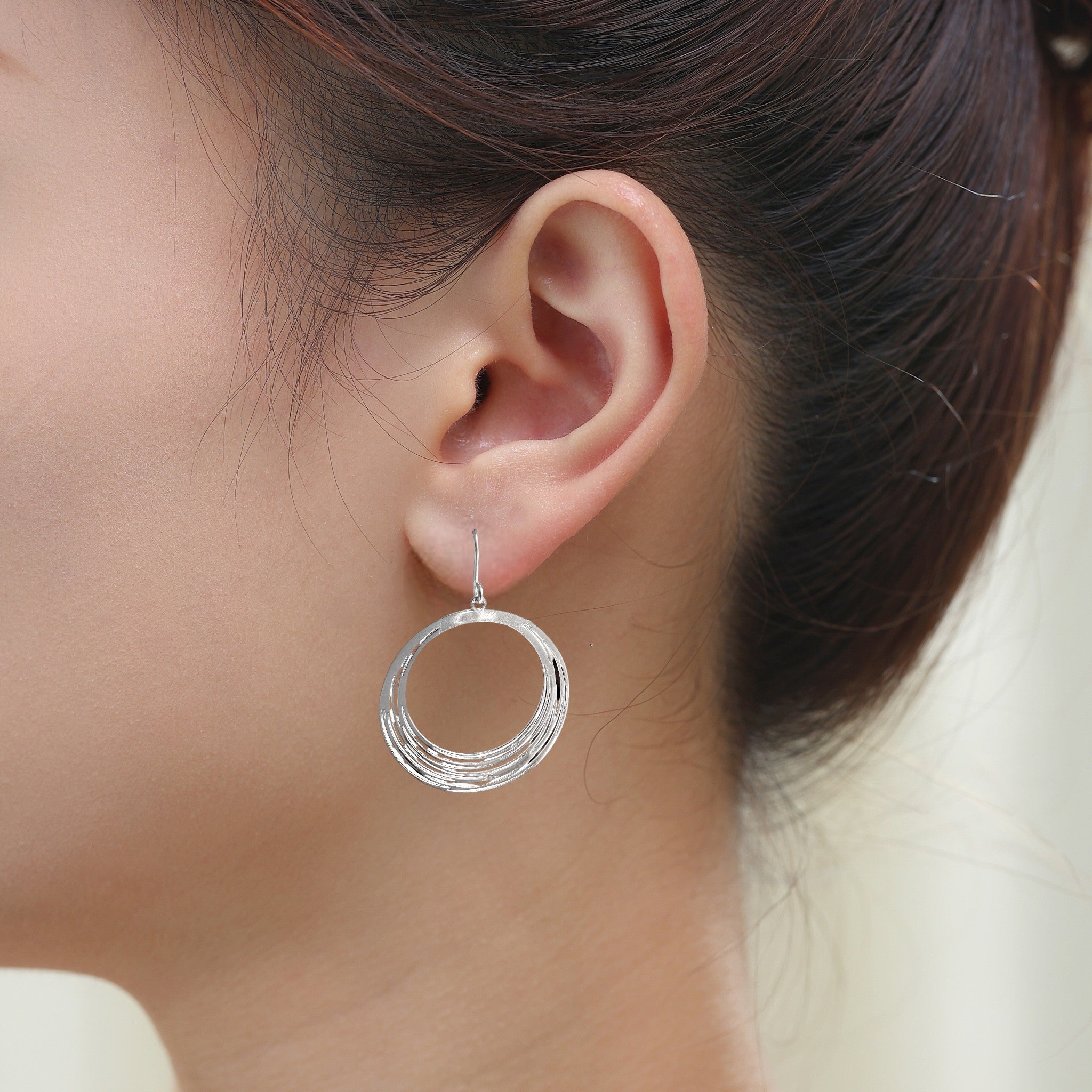 Silver String Ring earrings that are round and a titanium hook on a white young woman