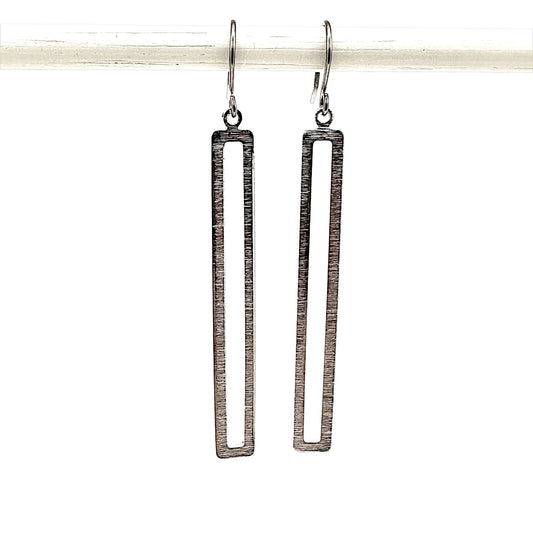 Silver rectangular loop earring with a titanium hook on a white background