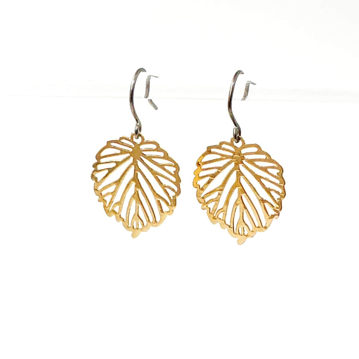 Small Monstera Leaf Earrings with a titanium hook on a white background