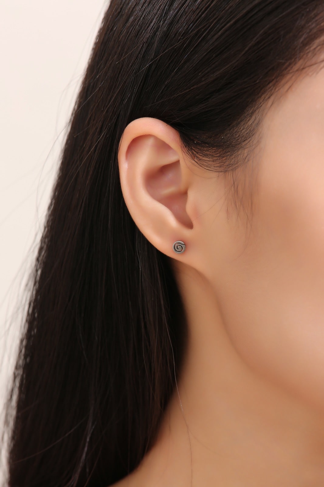 Small Swirl Titanium Studs -solid titanium studs and backs- Feature a small and minimal design on a white woman. +