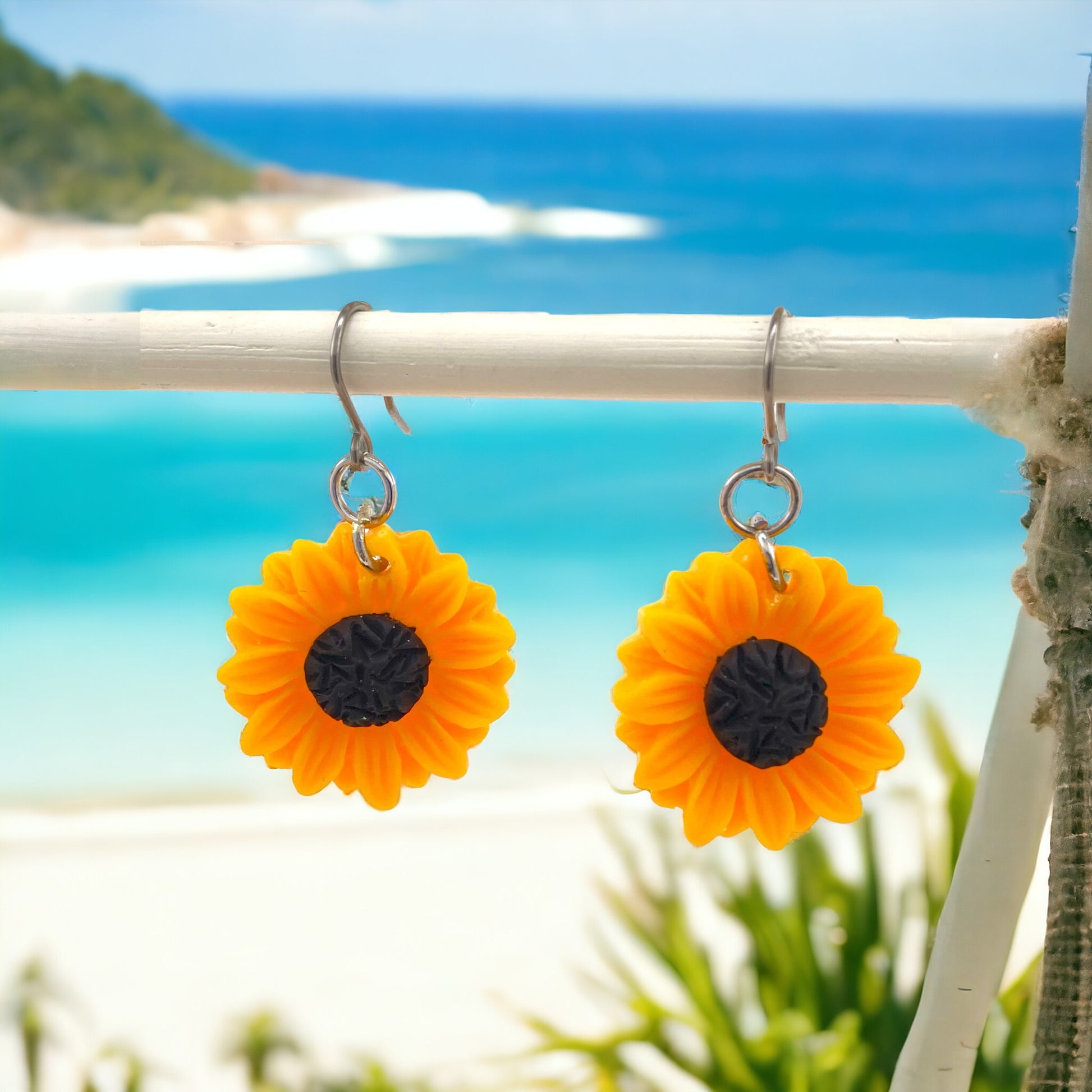 Sunflower earrings with a titanium hook on a water background