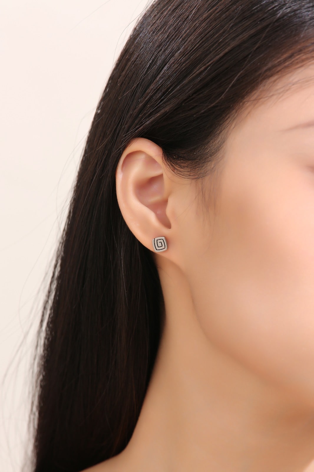 Swirl Titanium Studs -solid titanium studs and backs- Feature a small and minimal design on a white woman. +