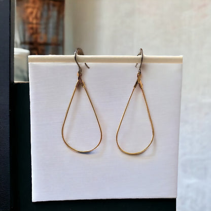 Tear drop hoop earrings with a titanium hook on a white background