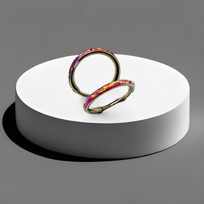 Titanium 8 mm coloured hoops on a white circular stand against a gray background