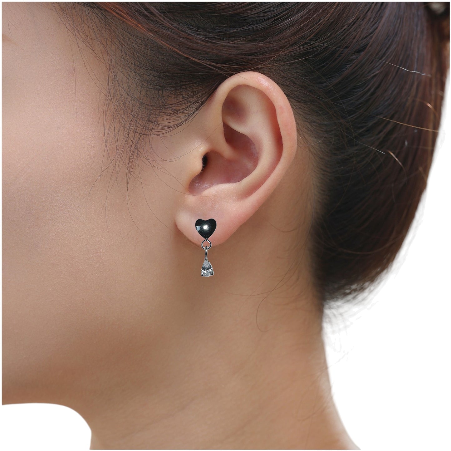 Titanium earring with heart and teardrop hanging gem worn by a person with a neutral background