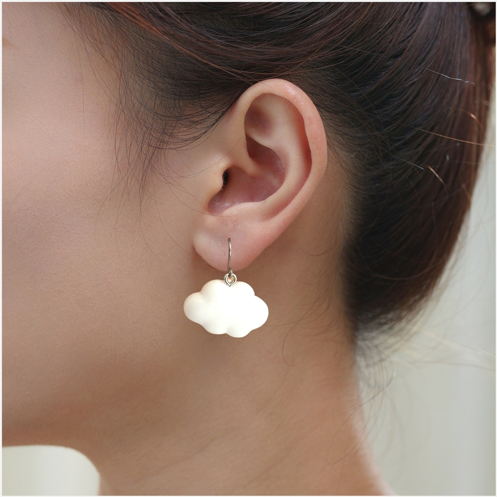 White Cloud earrings with titanium hook. on a white young woman