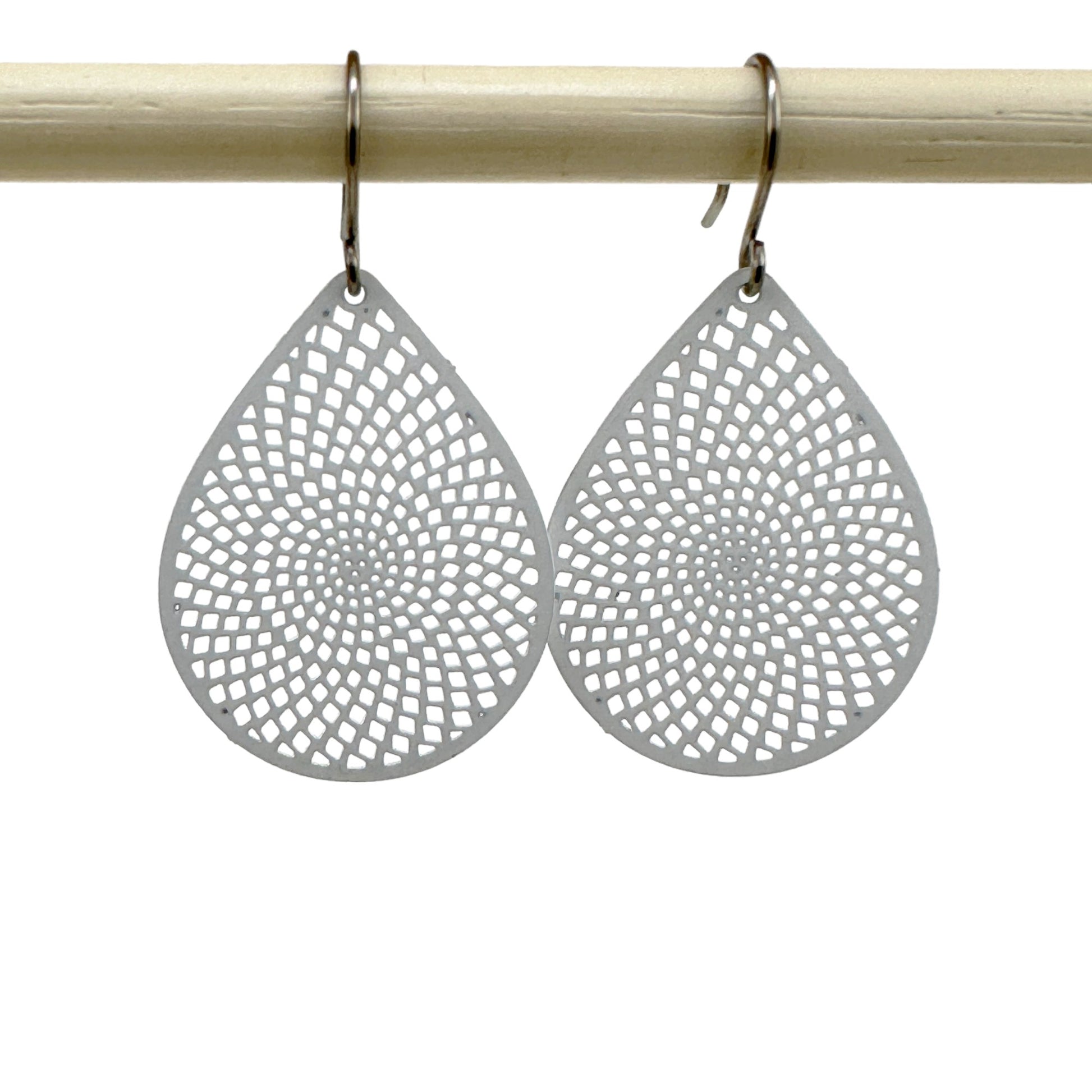 White teardrop earrings with titanium hook on a white background