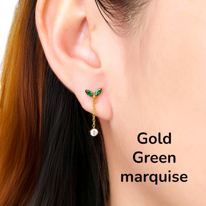 Close-up of an ear wearing a gold green leaf-shaped titanium flat back earring on a woman
