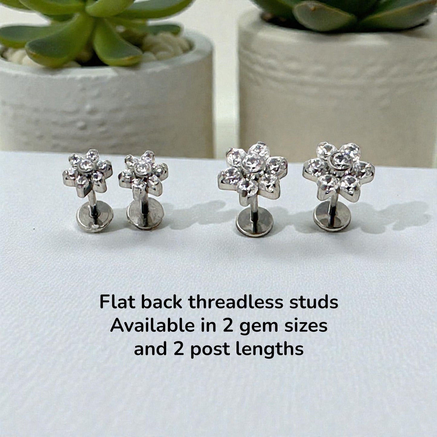 Titanium flower-shaped earrings on a white surface with text about product details.