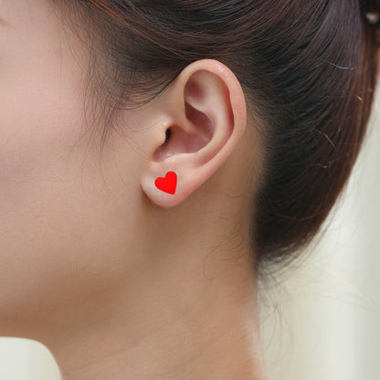 Red heart studs solid titanium studs and backs Feature a small and minimal design on a white woman. 