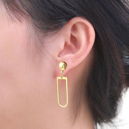 Interchangeable magnetic ti-go gold earring worn on an ear with a neutral background