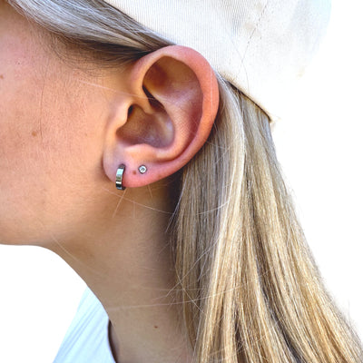 Titanium Small Hoops 11mm. Mini titanium earring pair, on a white young woman.