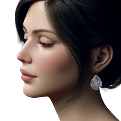 White teardrop earrings with titanium hook. on a white young woman.