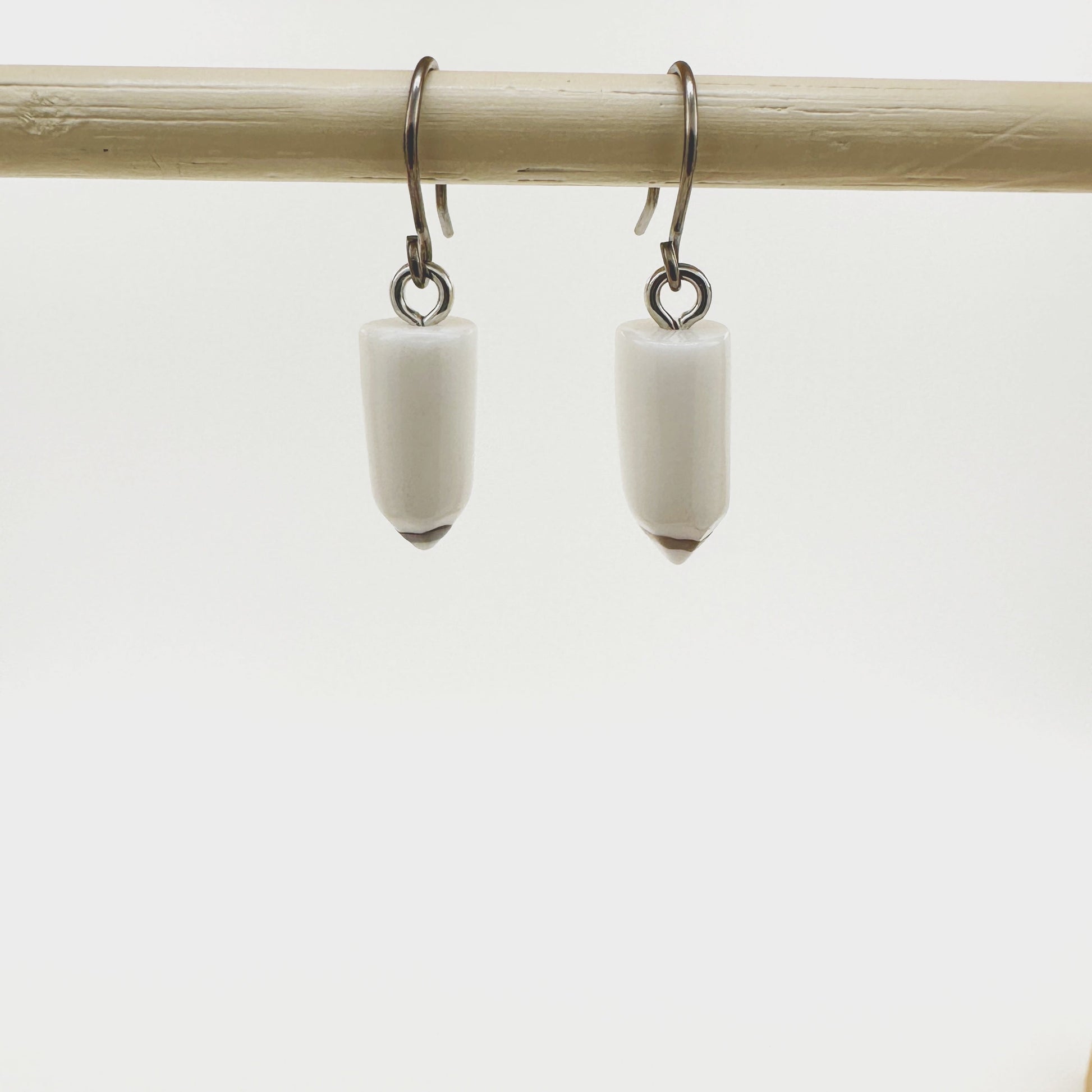 Pencil earrings with a titanium hook on a white background. white