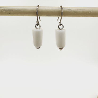 Pencil earrings with a titanium hook on a white background. white