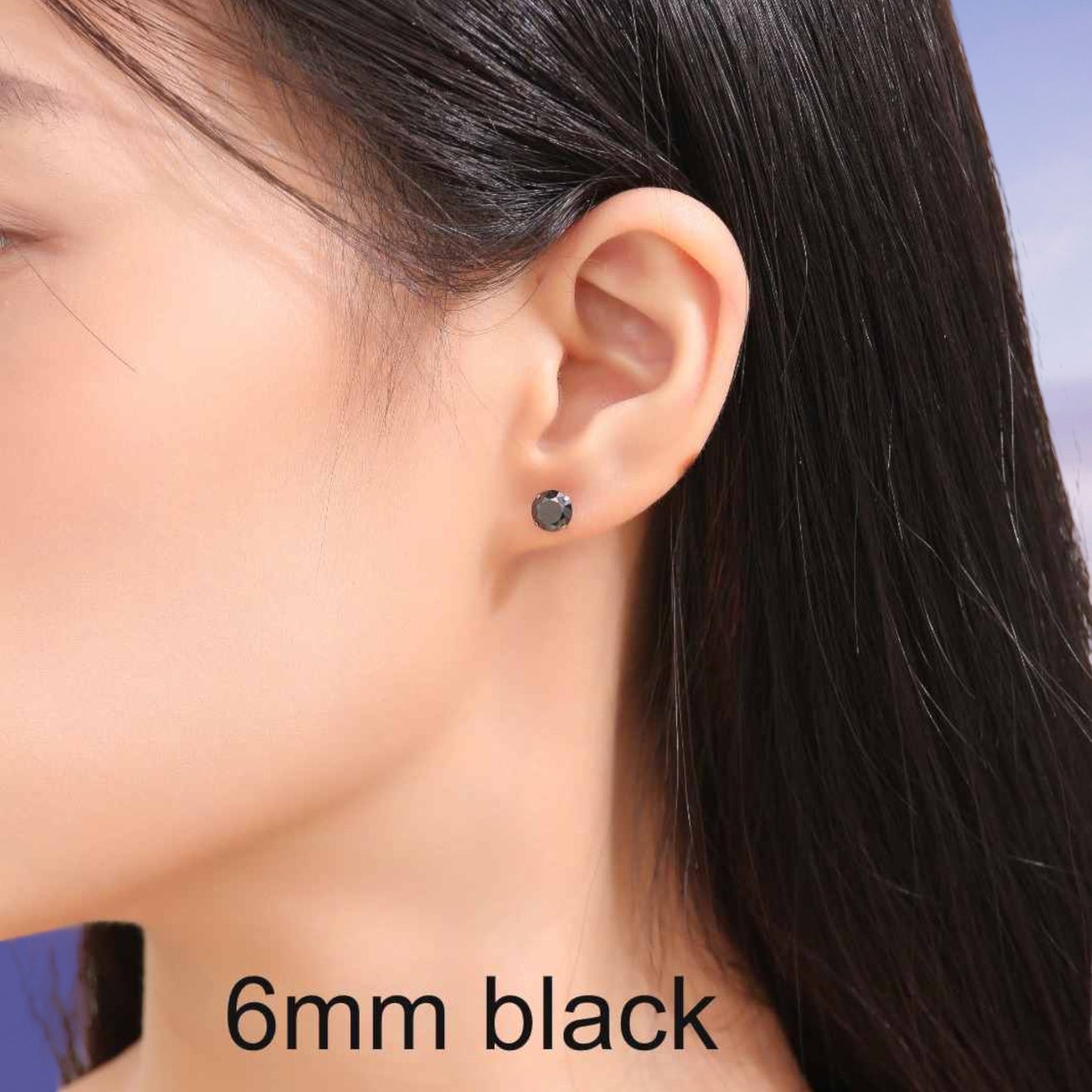 Close-up of an ear wearing a black titanium earring with '6mm black' text.