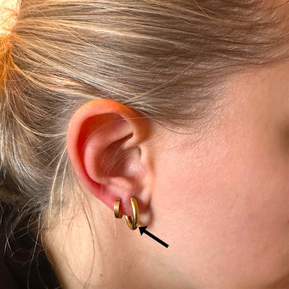 Titanium Gold hoop earring worn by a woman no background