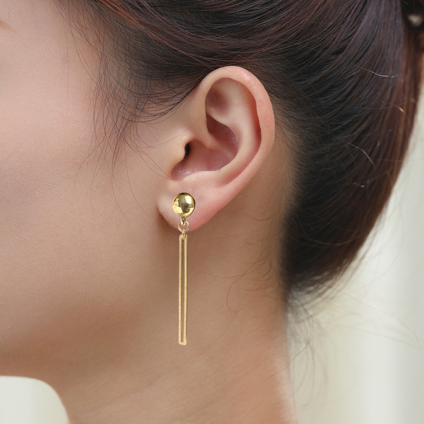 TI-GO Gold narrow rectangular loop earring. Detachable earrings for a truly hypoallergenic jewellery on a  young woman.