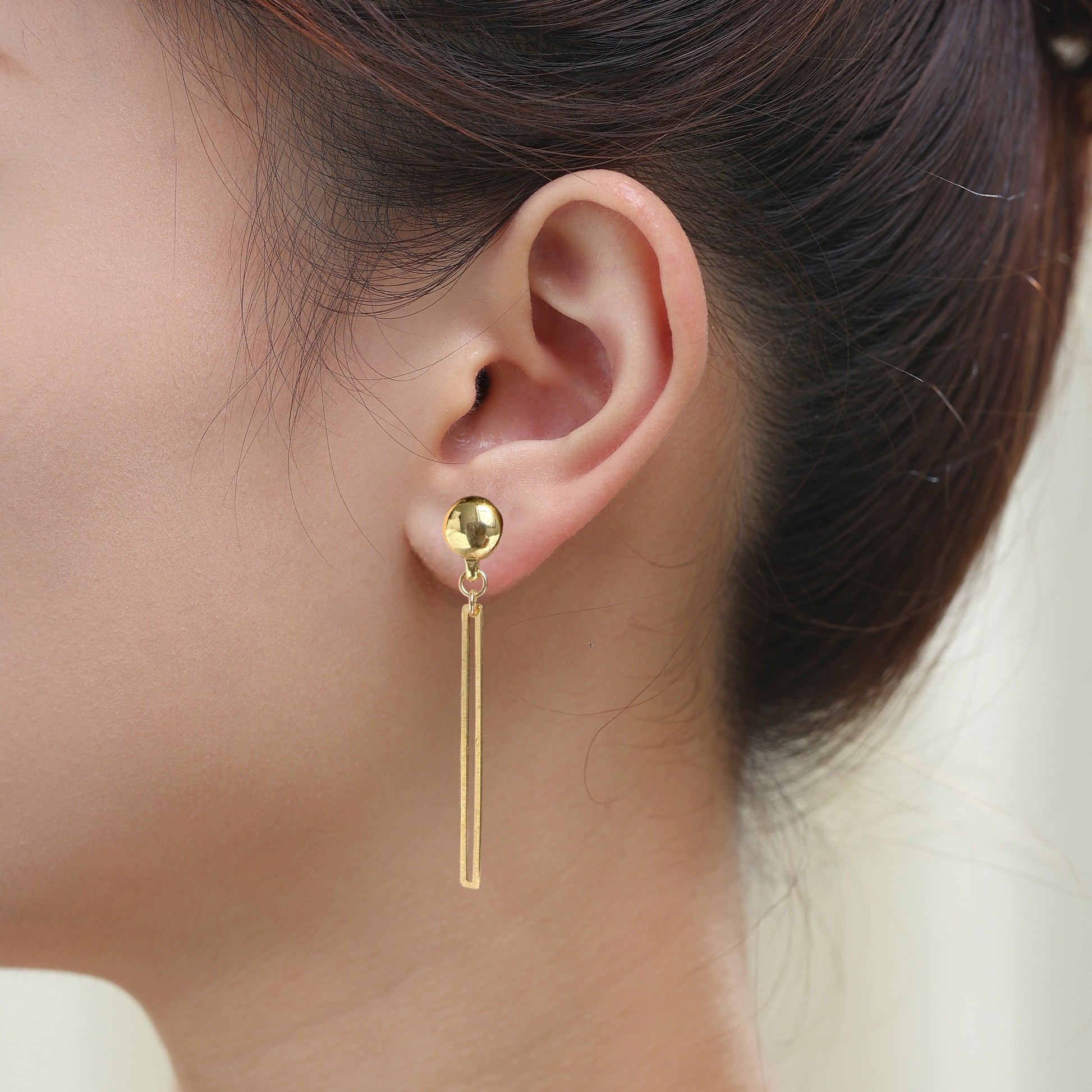 TI-GO Gold narrow rectangular loop earring. Detachable earrings for a truly hypoallergenic jewellery on a  young woman.