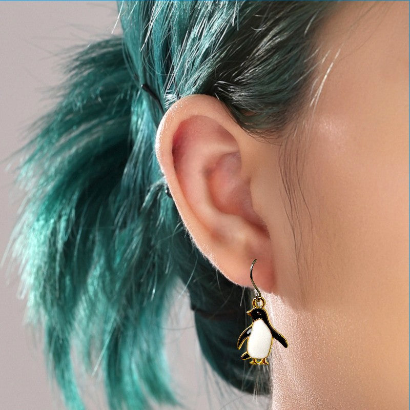 penguin hypoallergenic titanium earrings on a woman 