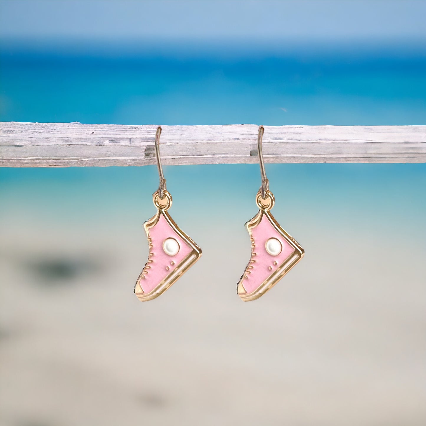Running Shoe Charm Drop Earrings with a titanium hook on a white background . pink