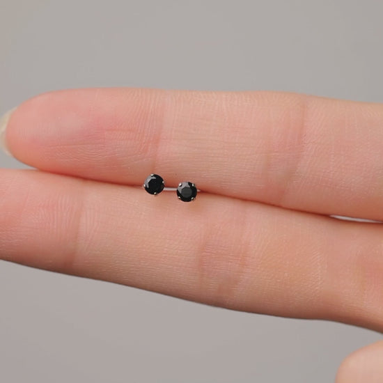 Black titanium earring Close-up of an ear and hand 