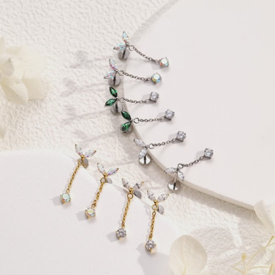 titanium flat back threadless earrings with  leaf like tops and gold chains on a woman avalable in 5 colours