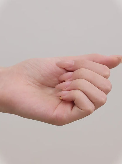 Close-up of an woman wearing a gold titanium hoop earring and in her hand