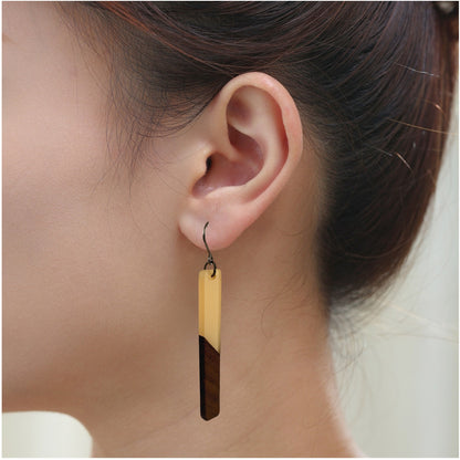 Translucent wood earrings with titanium hook. on a white young woman. brown