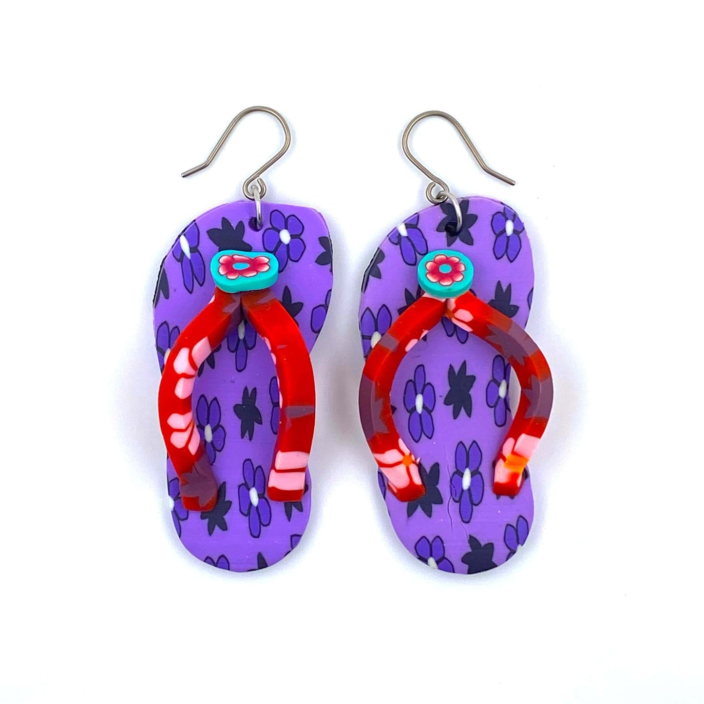 Flip flop earrings in purple with a titanium hook on a white background