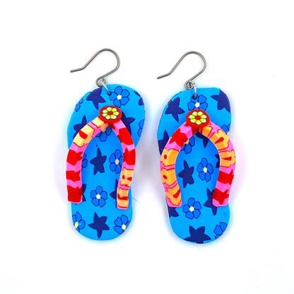 Flip flop earrings in blue with a titanium hook on a white background