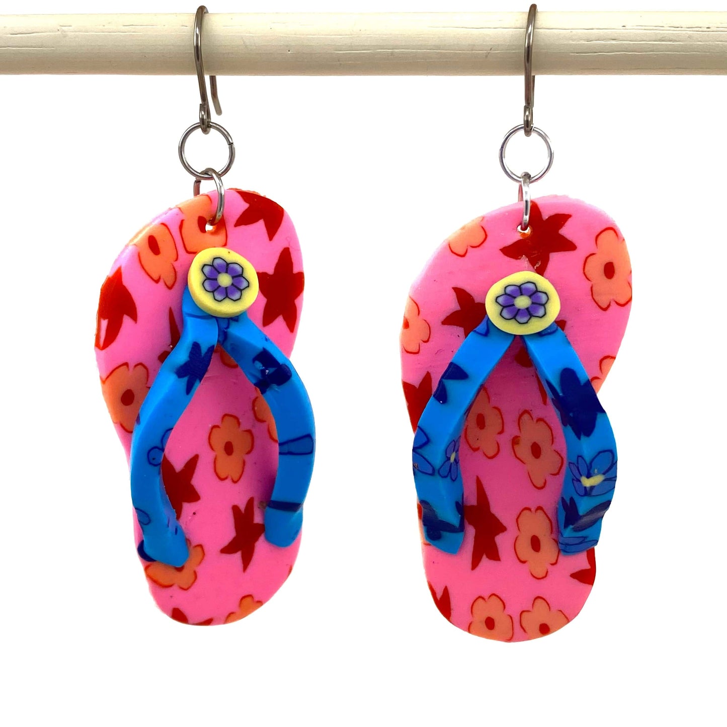 Flip flop earrings in pink with a titanium hook on a white background