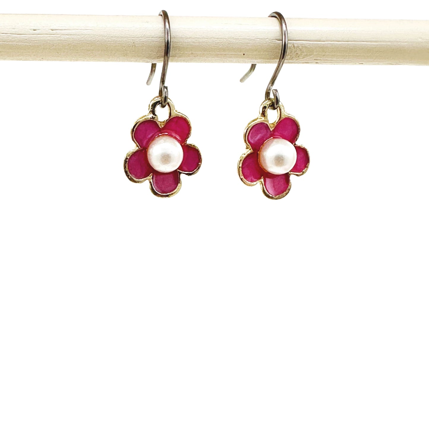 Forget-Me-Not Charm earrings in pink with a pearl in the center and a titanium hook on a white background