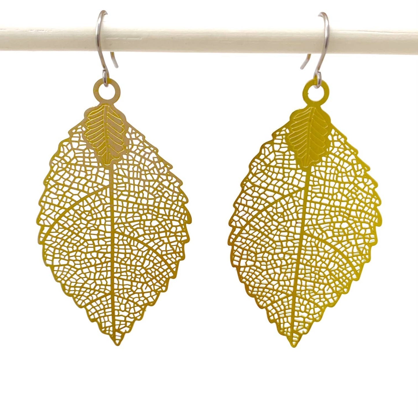 Gold leaf earring titanium on a white background